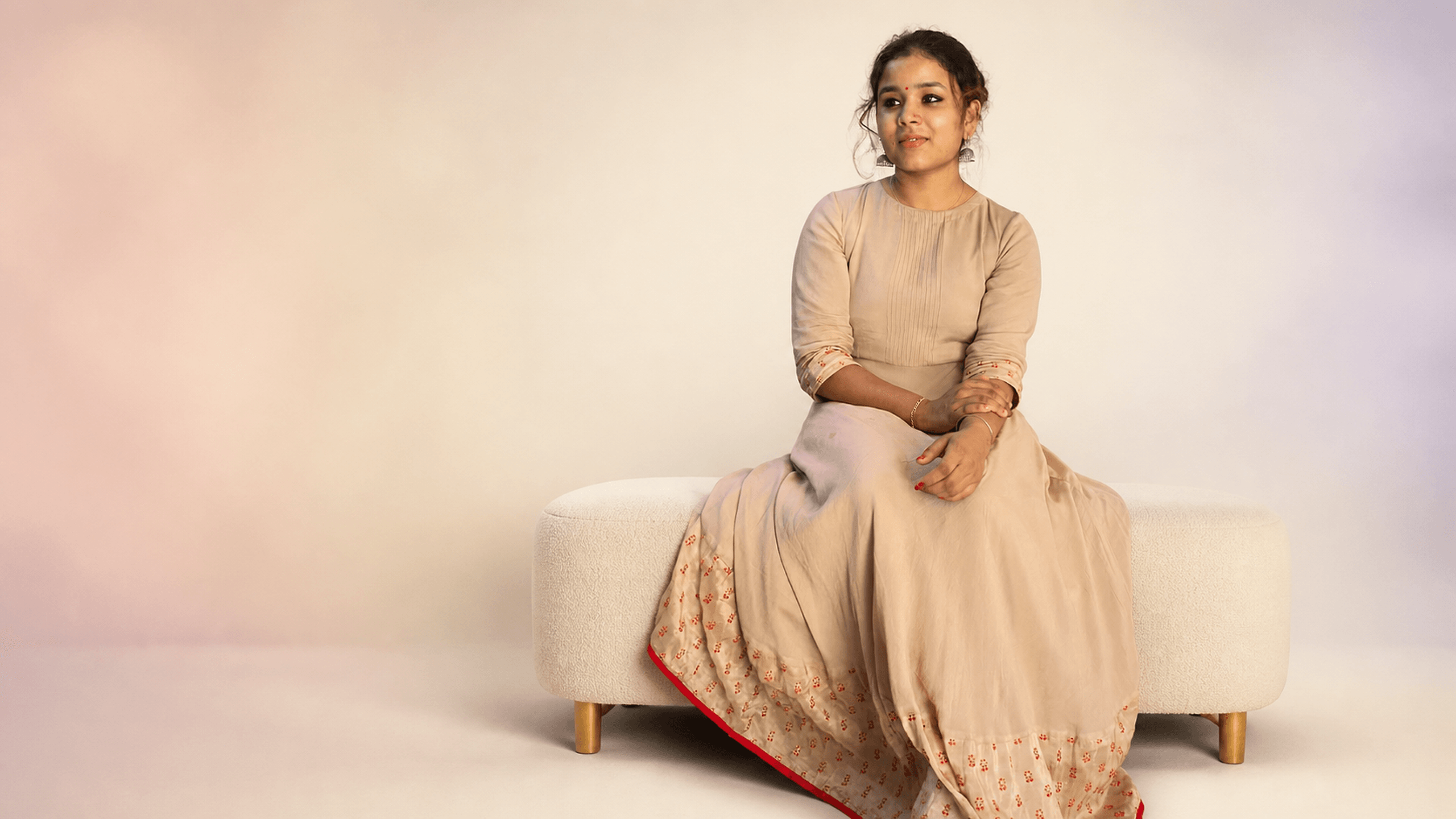 Woman wearing a beige embroidered dress from DZANE