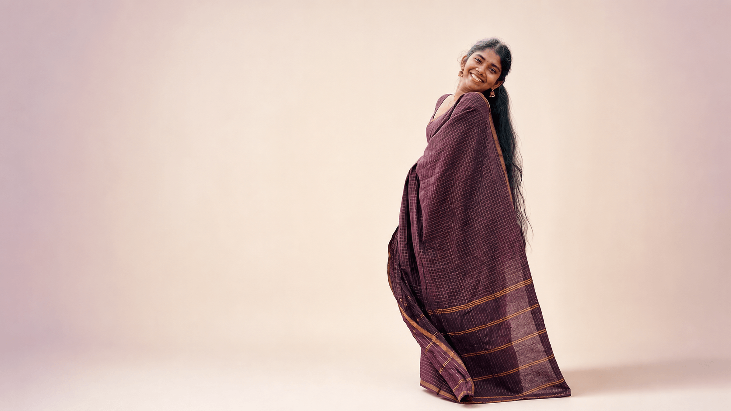 Woman wearing a plum saree from DZANE