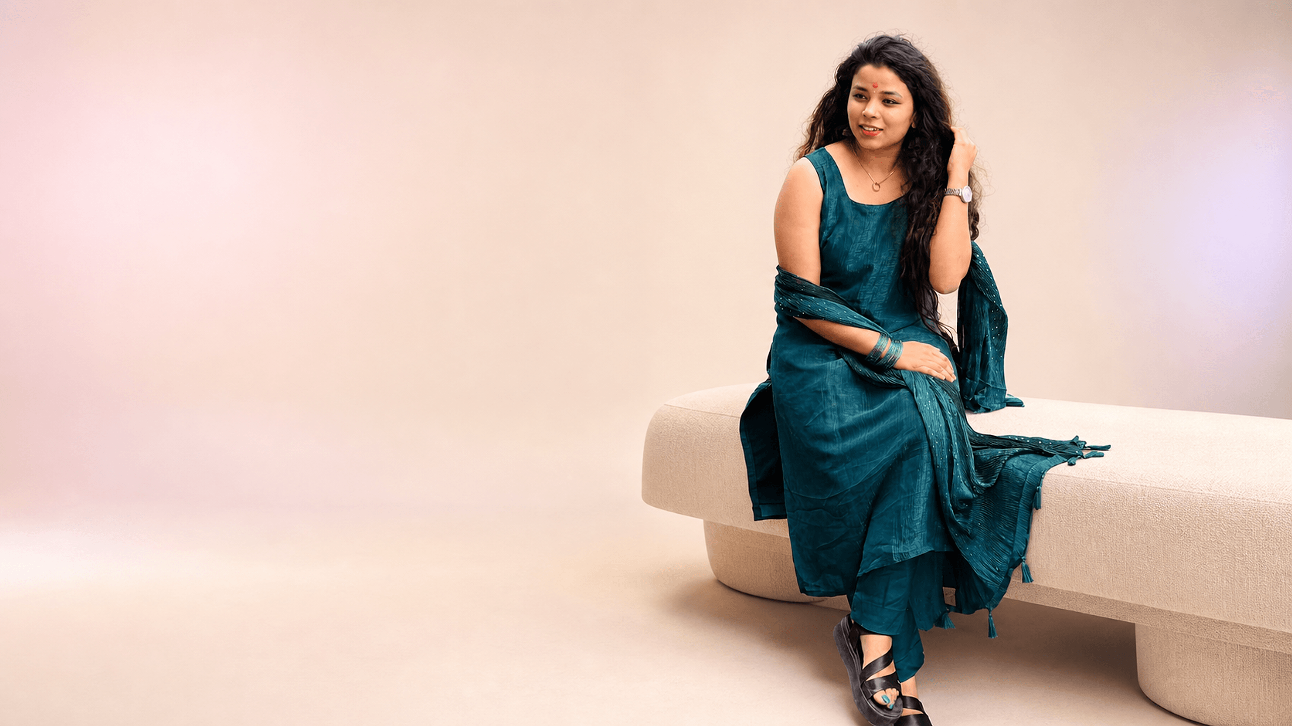Woman wearing a teal embroidered churidar set from DZANE
